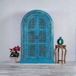 Handcrafted distressed blue carved wooden wardrobe cabinet with arched doors – front view.