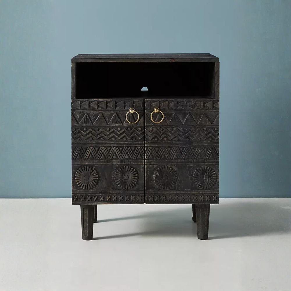 Handcrafted mango wood bedside cabinet with tribal carved design and antique brass handles