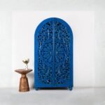 Royal blue hand-carved wooden wardrobe cabinet with arched doors – front view.